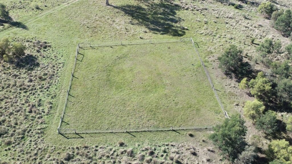 An aerial view of a ring in a grassy field