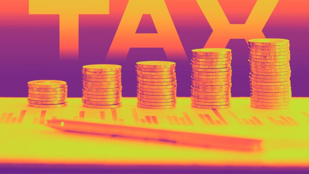 Coins piled up like a bar chart on top of tax documents with the word TAX in background.