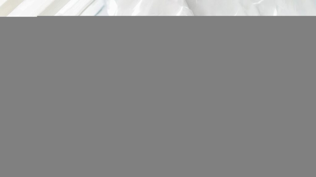 A photograph of a woman waking up and stretching in bed.